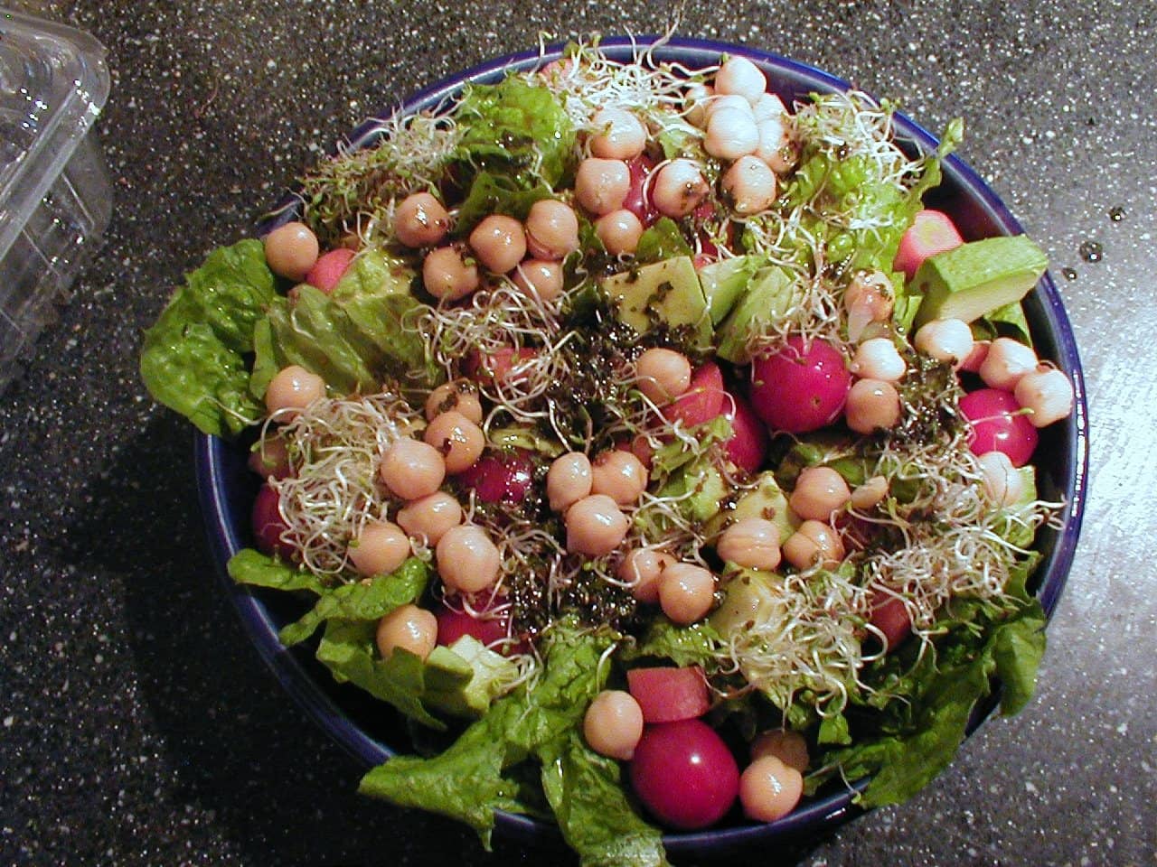 A garden salad bowl of lettuce, chickpeas, radishes and tender shoots