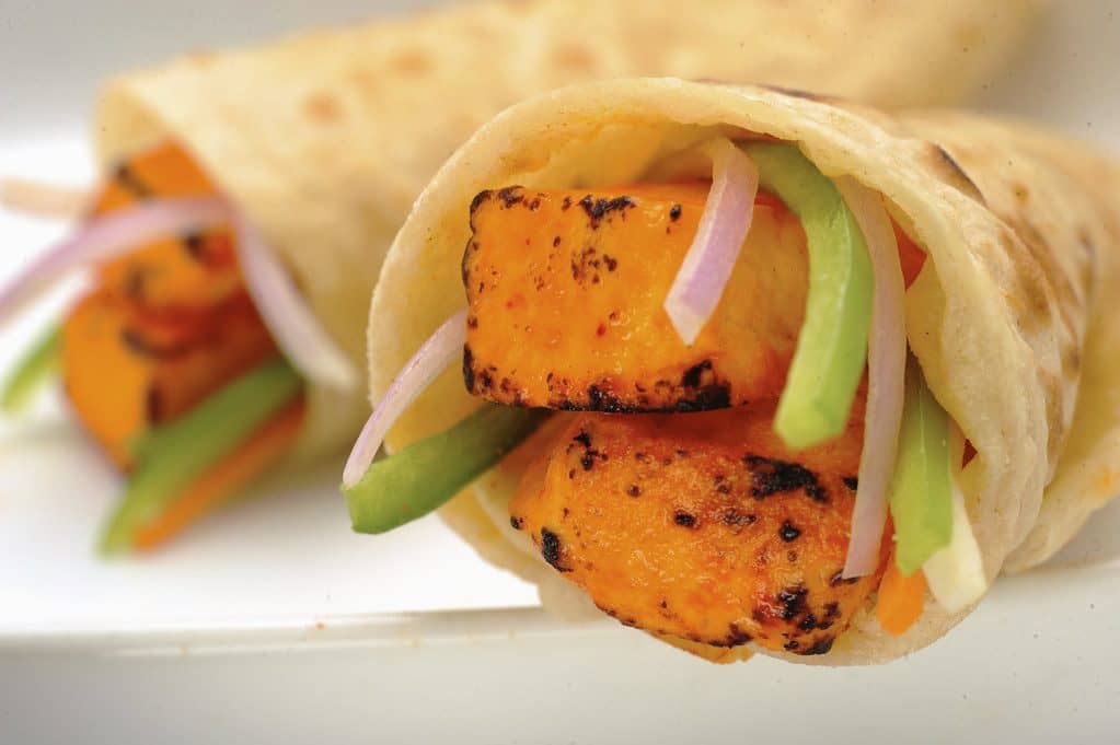 A paneer wrap filled with grilled paneer, peppers and greens